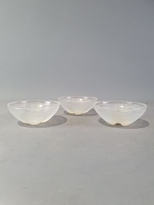 trois bols en verre blanc posés sur une table blanche