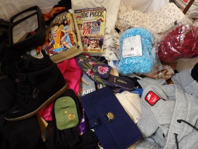a pile of clothing and other items on a bed