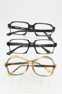 three pairs of eyeglasses sitting on top of each other