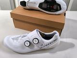 two pairs of white shoes sitting on top of a cardboard box