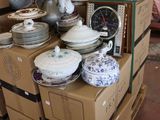boxes stacked on top of each other in a room filled with dishes
