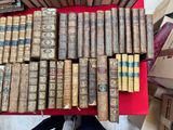 une image représentant une pile de vieux livres posée sur une table rouge