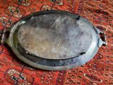 a silver plate on a red rug on the floor