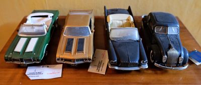 Plusieurs petites voitures sont alignées sur une table en bois