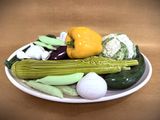 a plate of vegetables on a table with a brown background
