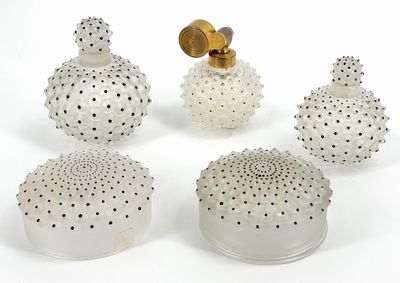 four white glass vases with gold accents on a white surface