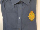 un gros plan sur une chemise bleue ornée d'un insigne