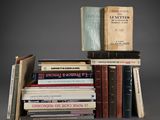 several books are stacked on top of each other on a gray surface