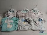 a lot of baby clothes on a hanger on the floor