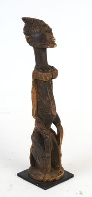 wooden statue of a man with a bird on his head