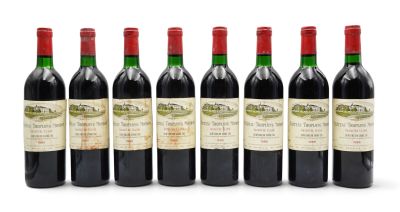 six bottles of red wine lined up in a row on a white surface