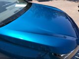 a blue car that is parked on the side of the road