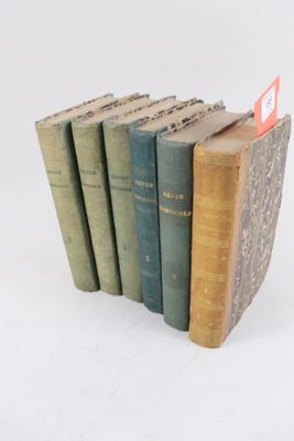 plusieurs vieux livres sont empilés sur une surface blanche