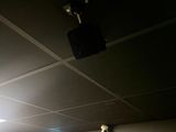 a black suitcase hanging from the ceiling in a dark room
