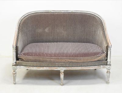 un canapé sur lequel est posé un coussin rayé, dans une pièce
