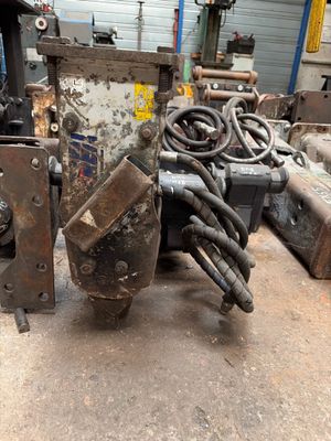 une machine posée par terre à côté d'un tas de câbles
