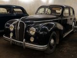 two old cars that are parked in a garage