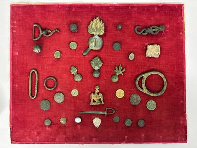 un tissu rouge sur lequel sont posés plusieurs objets métalliques