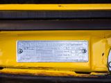 a close up of a yellow car with a metal plate on it