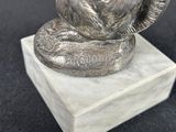 a statue of a squirrel sitting on top of a marble block