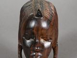 an image of a wooden sculpture of a woman ' s face
