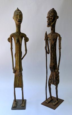 two wooden statues of a man and a woman standing next to each other
