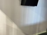 un téléviseur à écran plat fixé au mur dans un coin de la pièce