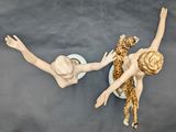 two figurines of a woman and a giraffe on a table