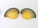 two yellow and black bras sitting next to each other on a white surface