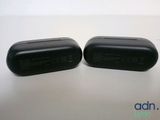 two black airpods sitting on top of a table next to each other