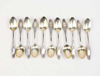 six silver spoons are lined up in a row on a white surface