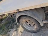 a white truck with a flat bed parked on the side of the road
