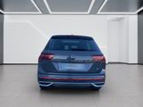 the rear end of a blue volkswagen e - pace parked in a white room
