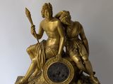 a gold statue of a man and a woman sitting on a clock