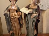deux figurines représentant des femmes debout l'une à côté de l'autre sur une table