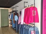 a lot of clothes hanging on a rack in a store