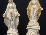 une paire de statues blanches et dorées représentant la Vierge Marie et Jésus