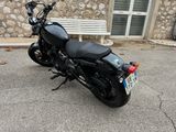a black motorcycle parked in front of a stone building