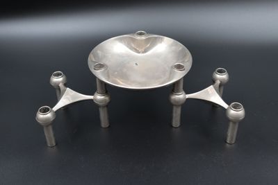 an image of a silver plate with three legs and a bowl on top of it
