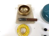 a small bowl, a wooden stick, and some other items on a table