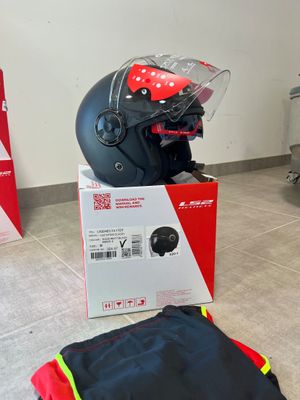 a helmet and a bag on the floor next to a luggage bag