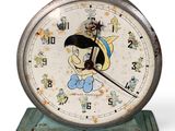 une horloge ornée d'un personnage de dessin animé, posée sur un socle