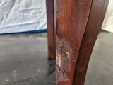 a close up of the legs of a wooden table with peeling paint