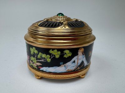 a gold and black box with a woman laying on it