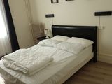 un lit avec des draps blancs et une tête de lit noire