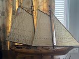 a model of a sailboat on a table next to a lamp