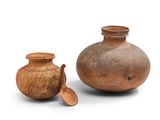 deux vases bruns posés l'un à côté de l'autre sur une surface blanche
