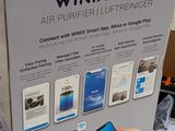 someone is holding a smart phone in front of a box of wifi