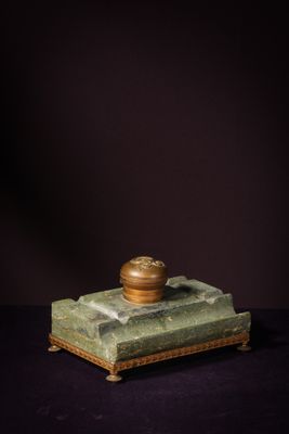 a green marble box with a gold lid on a black background