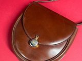 leather purse on a red surface with a chain around it